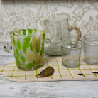 Set of glass tumblers with a decorative pitcher on a checkered surface