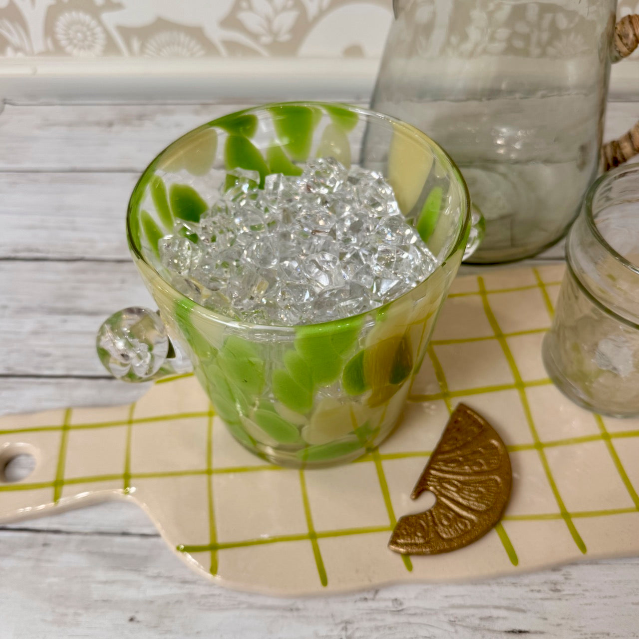 Green glass with decorative elements on a checkered surface