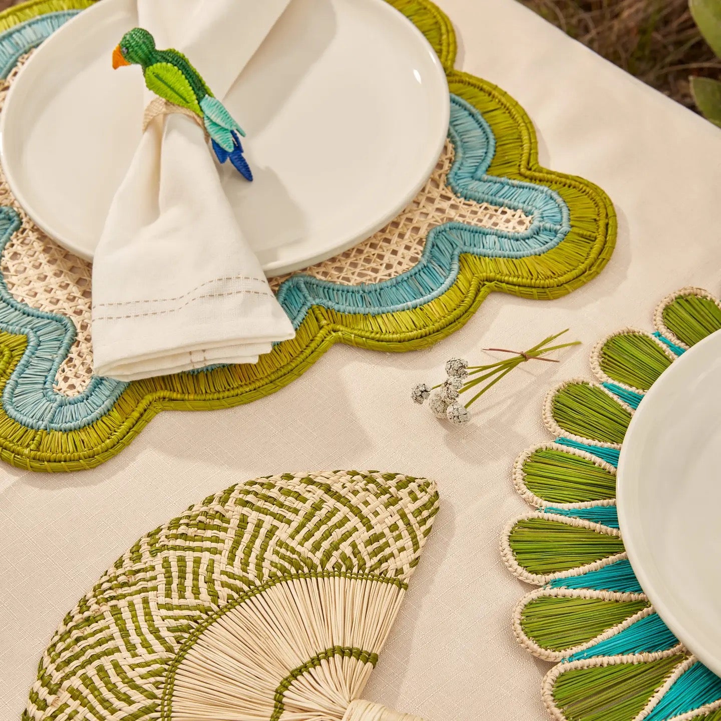 Decorative placemats with green and blue patterns on a white surface.