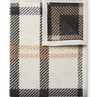 Plaid patterned fabric with black, white, and brown colors on a white background