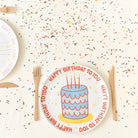 Children's birthday plate with cake design and 'Happy Birthday to You' text on a sprinkled surface.