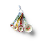 Set of four floral-themed measuring spoons hanging on a white background