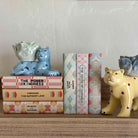 Decorative shelf with animal figurines and books on a neutral background