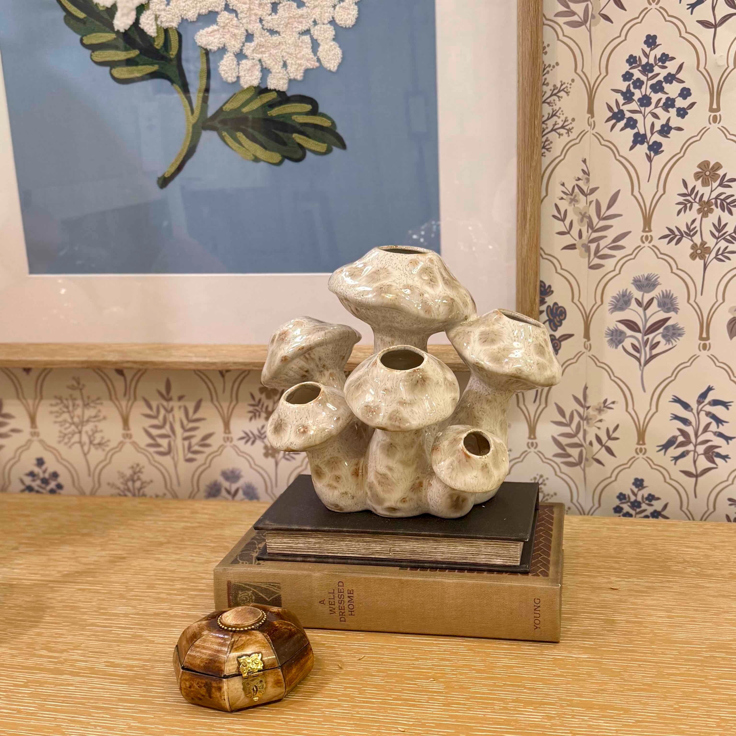 Decorative ceramic piece on a book with floral artwork in the background