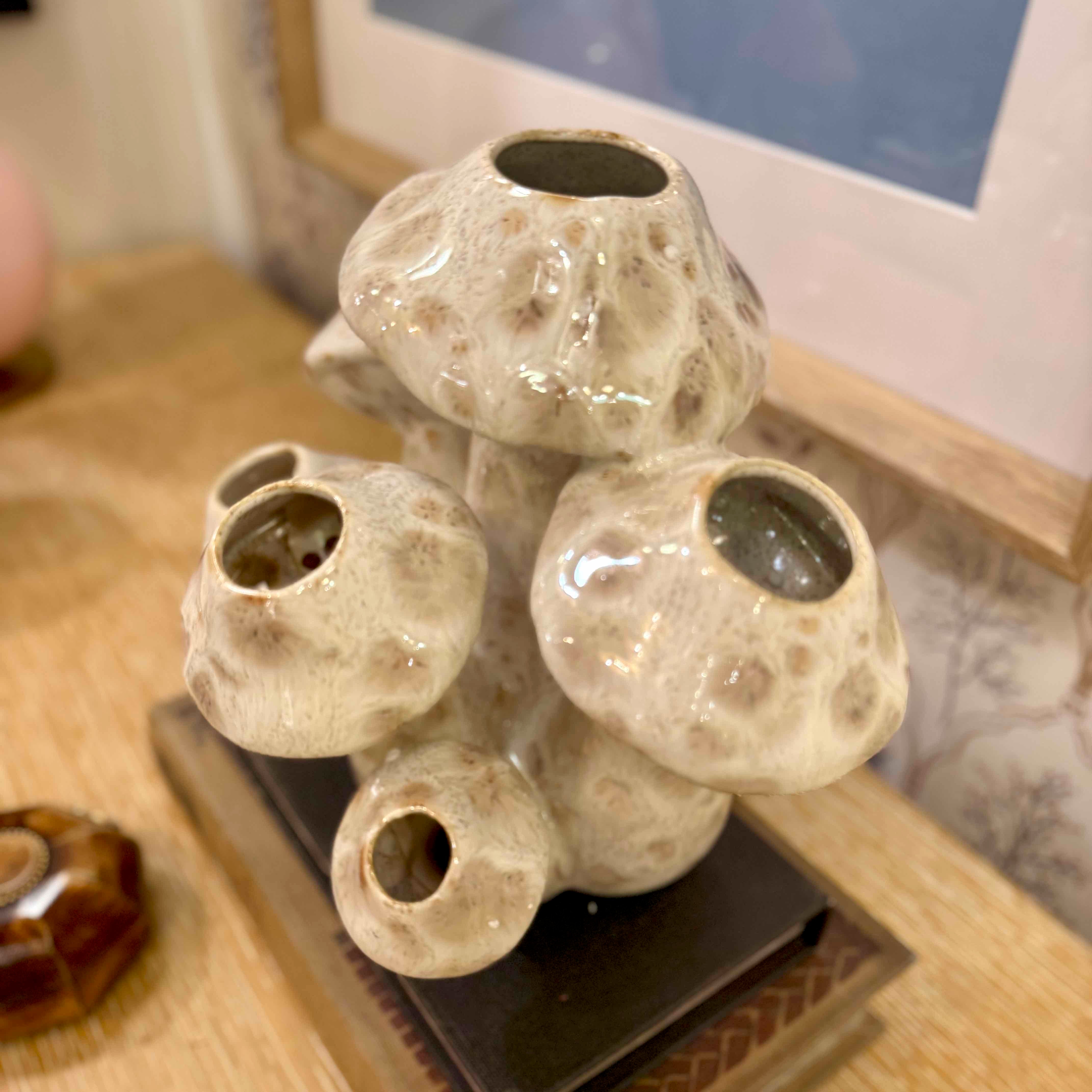 Ceramic vase with multiple nozzles on a wooden surface
