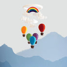 Colorful hot air balloon and rainbow mobile against a mountain backdrop
