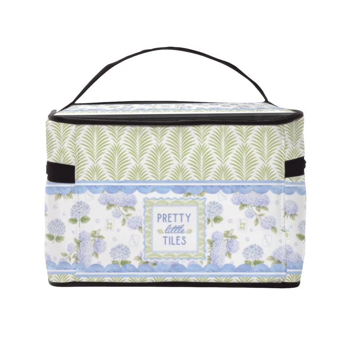 A rectangular insulated lunch bag with a black handle and trim, featuring a floral and leaf pattern in sage green, lavender, and light blue, with a central label that reads 'PRETTY little TILES'.