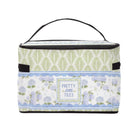 A rectangular insulated lunch bag with a black handle and trim, featuring a floral and leaf pattern in sage green, lavender, and light blue, with a central label that reads 'PRETTY little TILES'.