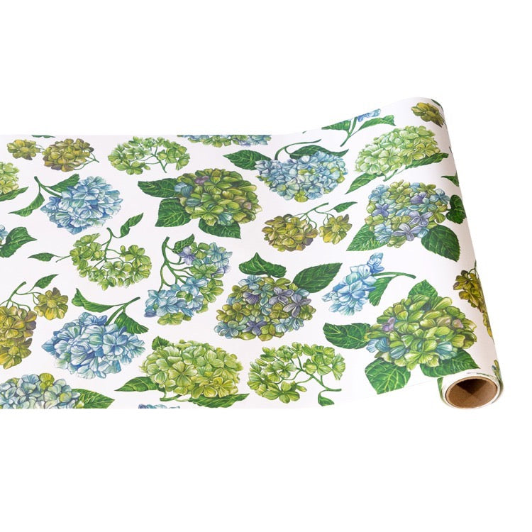 Roll of paper with green and blue floral pattern on a white background