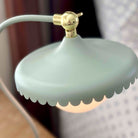 Decorative lamp with a gold fixture and scalloped edge on a blurred background