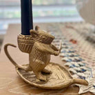 Brass mouse-shaped candle holder on a wooden surface