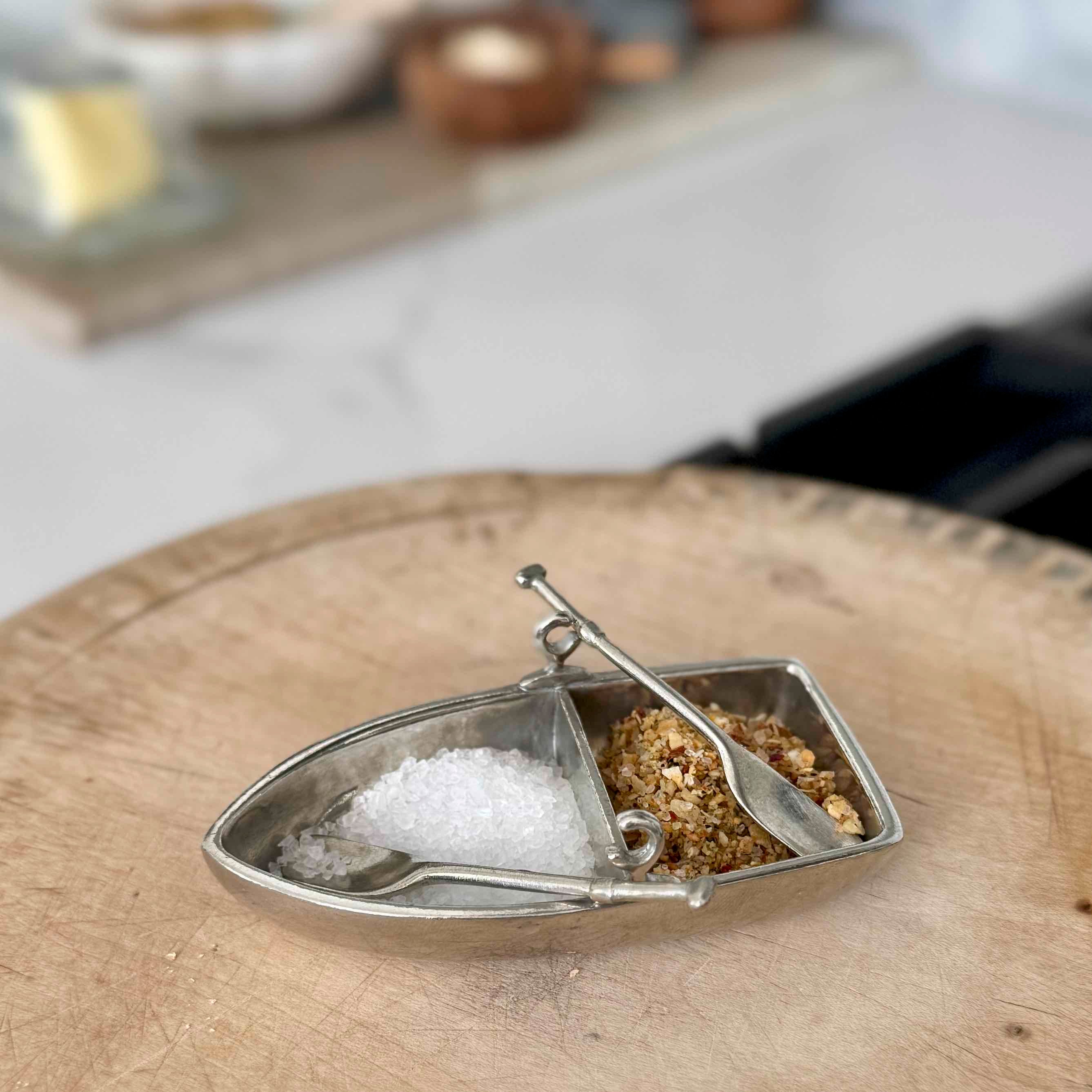 Decorative salt and pepper shaker set on a wooden surface with a blurred background.