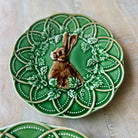 Decorative green plate with a rabbit design on a wooden surface