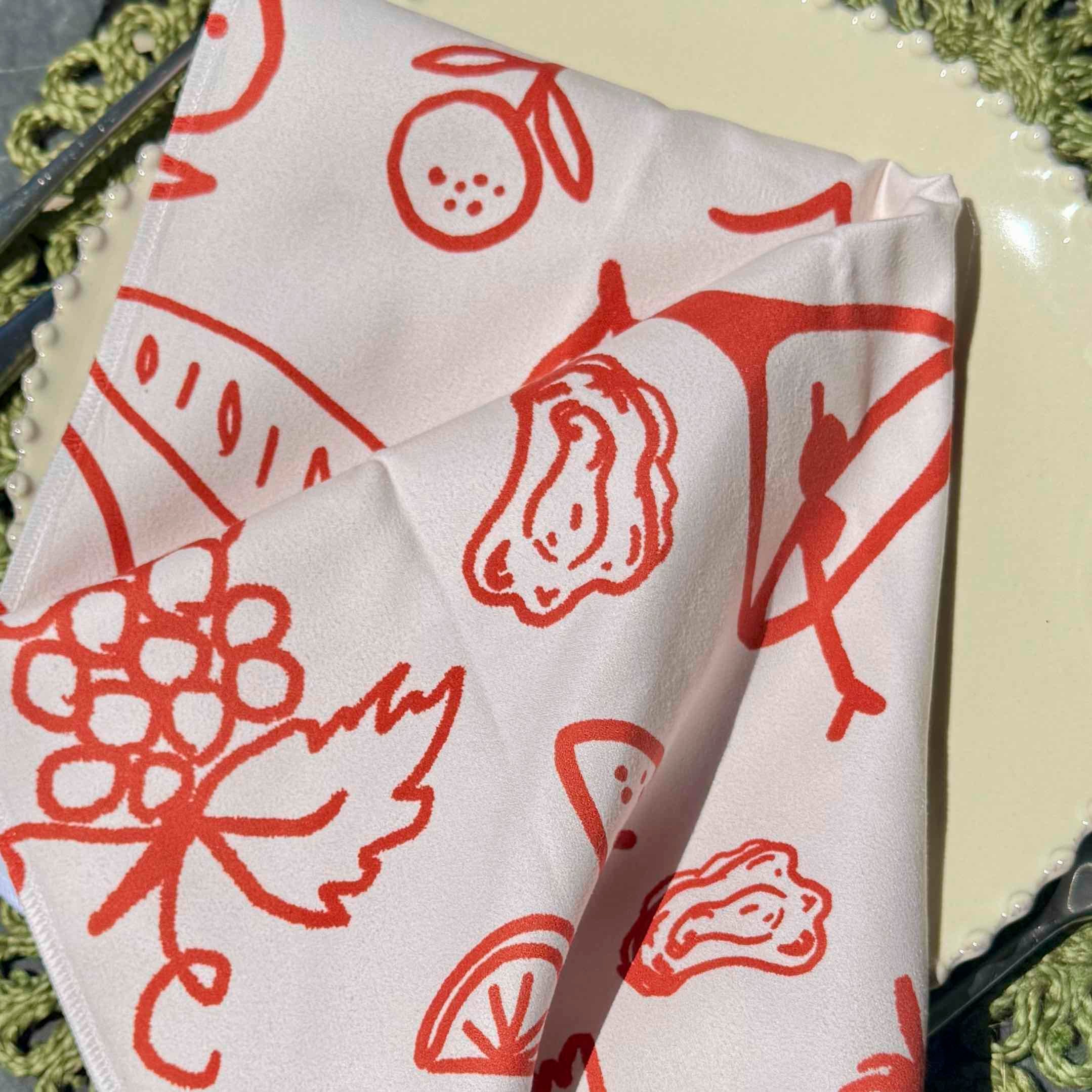 White fabric with red food-themed patterns on a textured surface