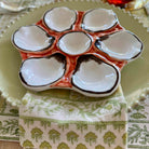 Ceramic oyster plate with multiple compartments on a patterned tablecloth