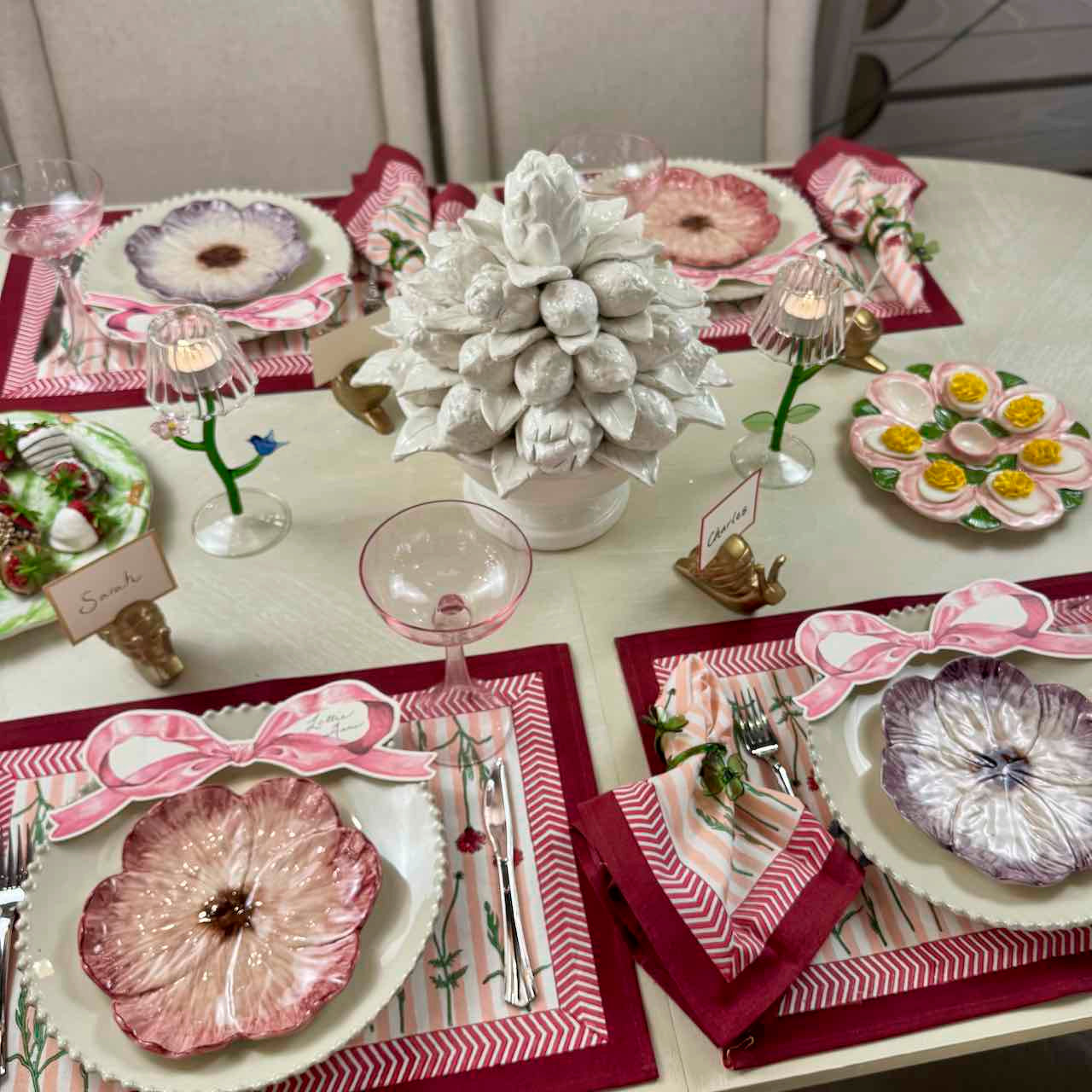 Elegant table setting with floral plates, candles, and decorative centerpieces.