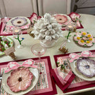 Elegant table setting with floral plates, candles, and decorative centerpieces.