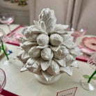 White ceramic pineapple on a table with decorative elements