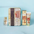 Set of beauty products including a tin, bottle, and tube with cake-themed packaging on a light blue background.