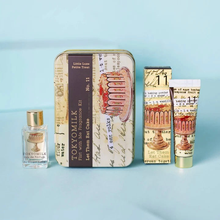 Set of beauty products including a tin, bottle, and tube with cake-themed packaging on a light blue background.