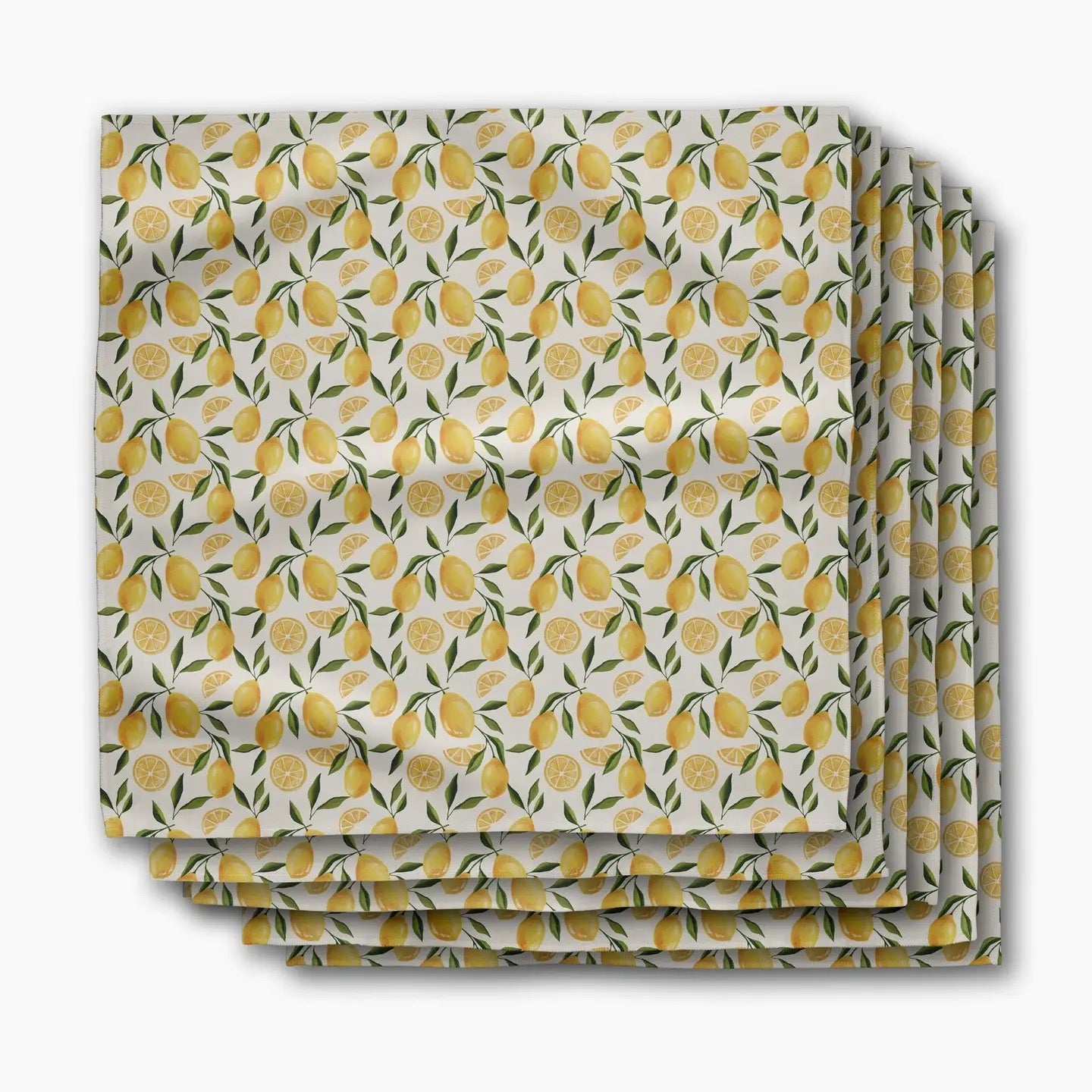 Stack of folded fabric with lemon pattern on a white background