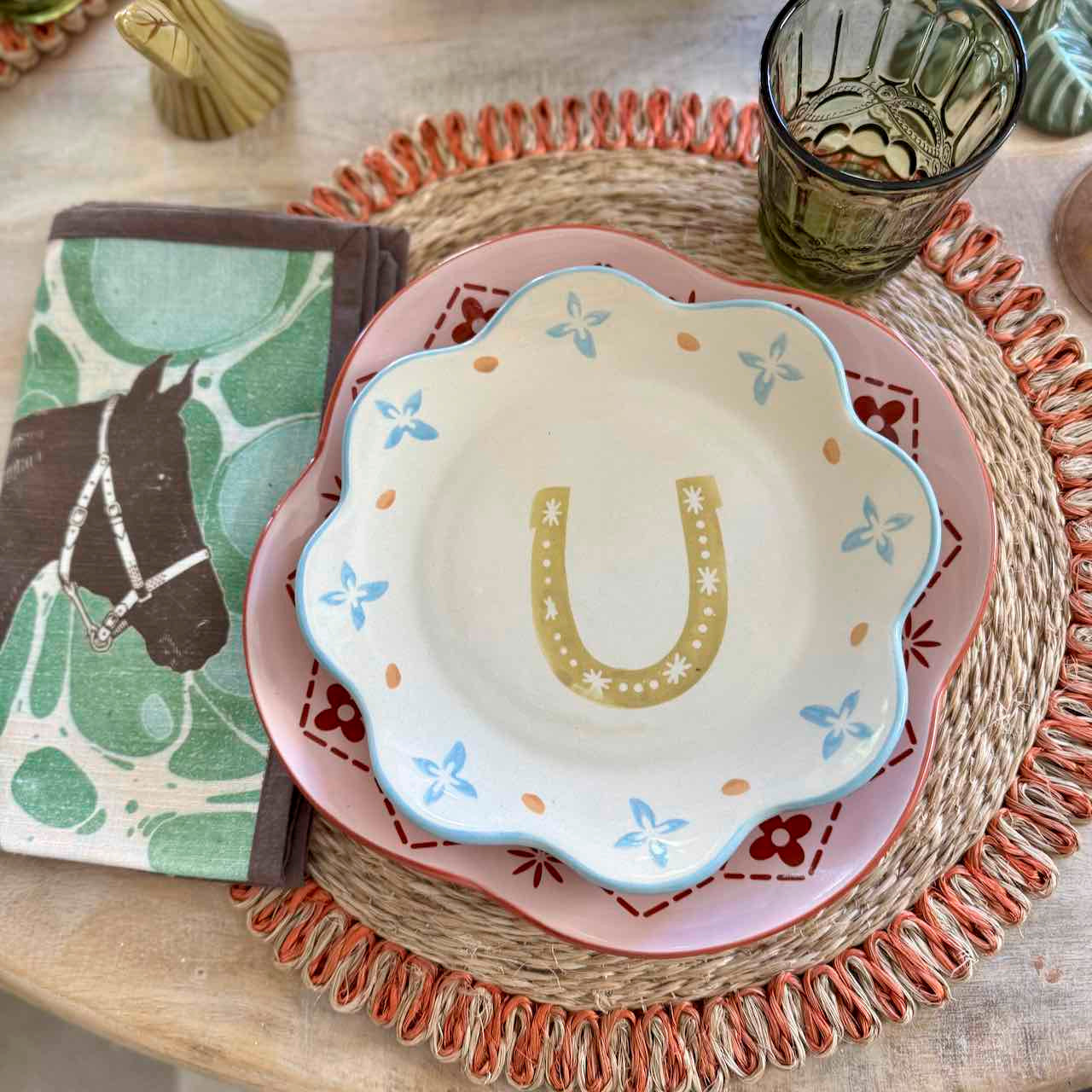 Stack of ceramic plates with decorative patterns on a woven placemat
