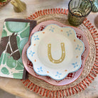 Stack of ceramic plates with decorative patterns on a woven placemat