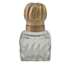 Clear glass perfume bottle with a gold cap on a white background