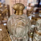 Decorative glass bottle with gold lid on a blurred background