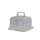 Clear glass cake stand with beige base on a white background
