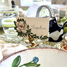 Table setting with a decorative name card featuring floral design and the name 'Sophie'.