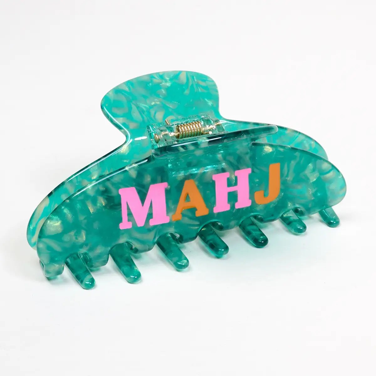 Turquoise hair clip with 'MAHJ' letters on a white background