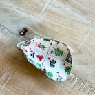 A small decorative shell-shaped object printed with a mahjong tile pattern, photographed on a light wood surface.