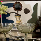 Decorative glassware with a vintage lamp and abstract art in the background