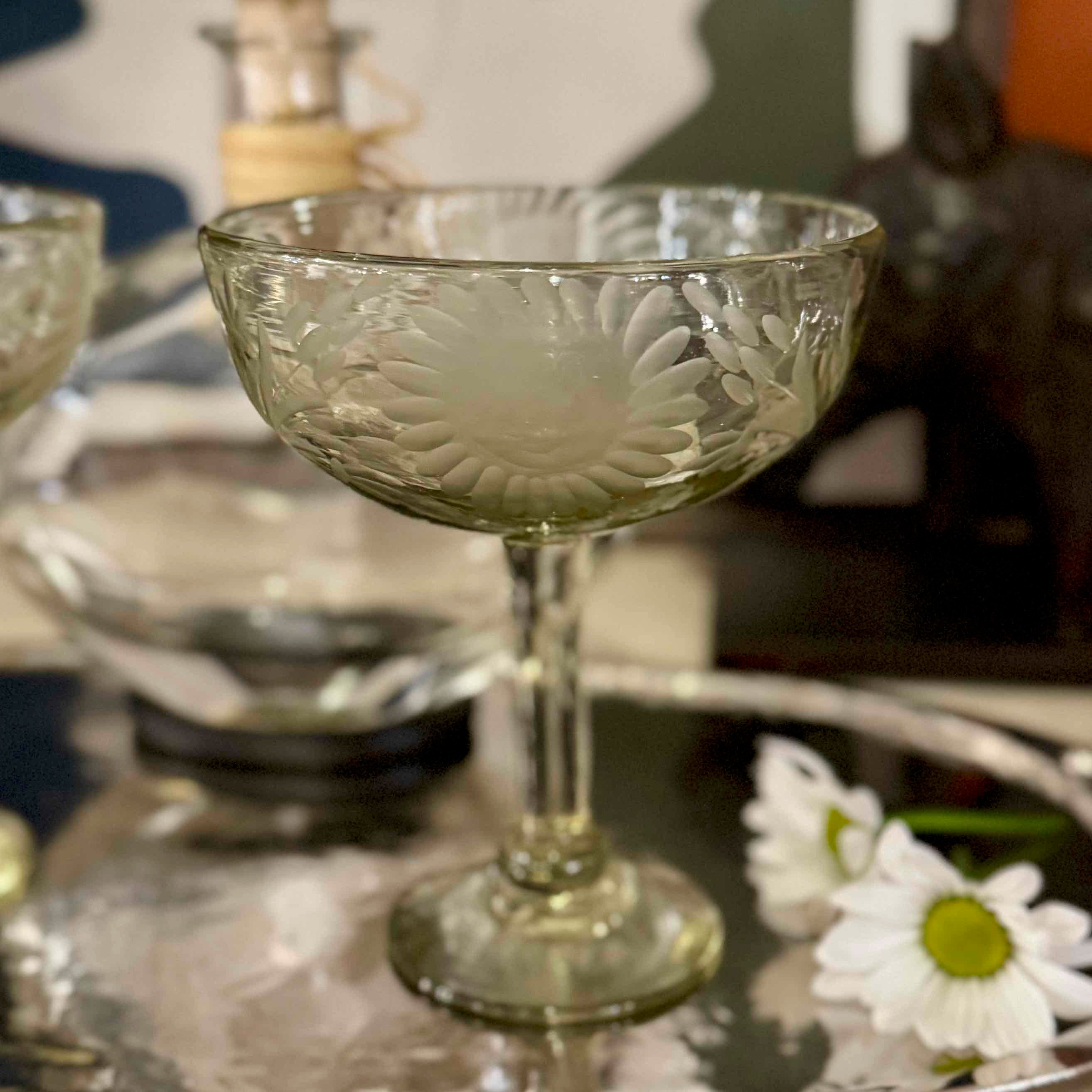 Decorative glass bowl with floral patterns on a reflective surface