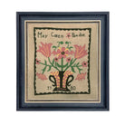 Framed needlepoint with floral design and text on a beige background