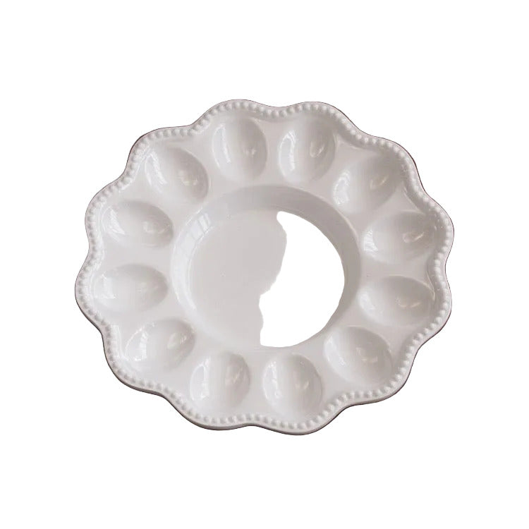 White ceramic dish with decorative edge on a wooden surface