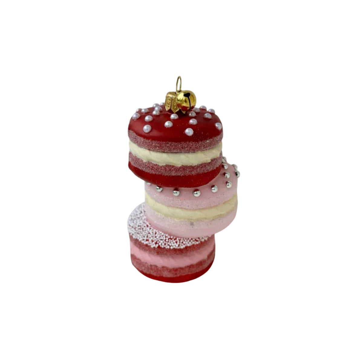 A stacked set of three macaron-shaped ornaments in red, pink, and light pink, decorated with white pearls and a small gold bell ornament on top, set against a plain white background.