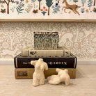 Decorative items including a small fountain, books, and animal figurines on a surface with a patterned wall in the background.