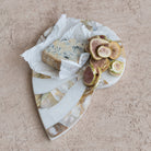 Marble cheese board with blue cheese and sliced figs on a beige surface