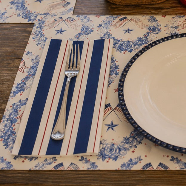 Placemat with blue and white floral pattern, red and white striped area, and silver fork on a wooden surface.