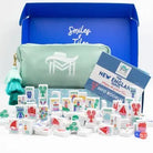 Collection of toys, a pouch, and an info booklet with 'Smiles & Tiles' branding on a white background.