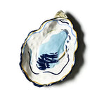 Decorative ceramic oyster shell with blue design on a white background
