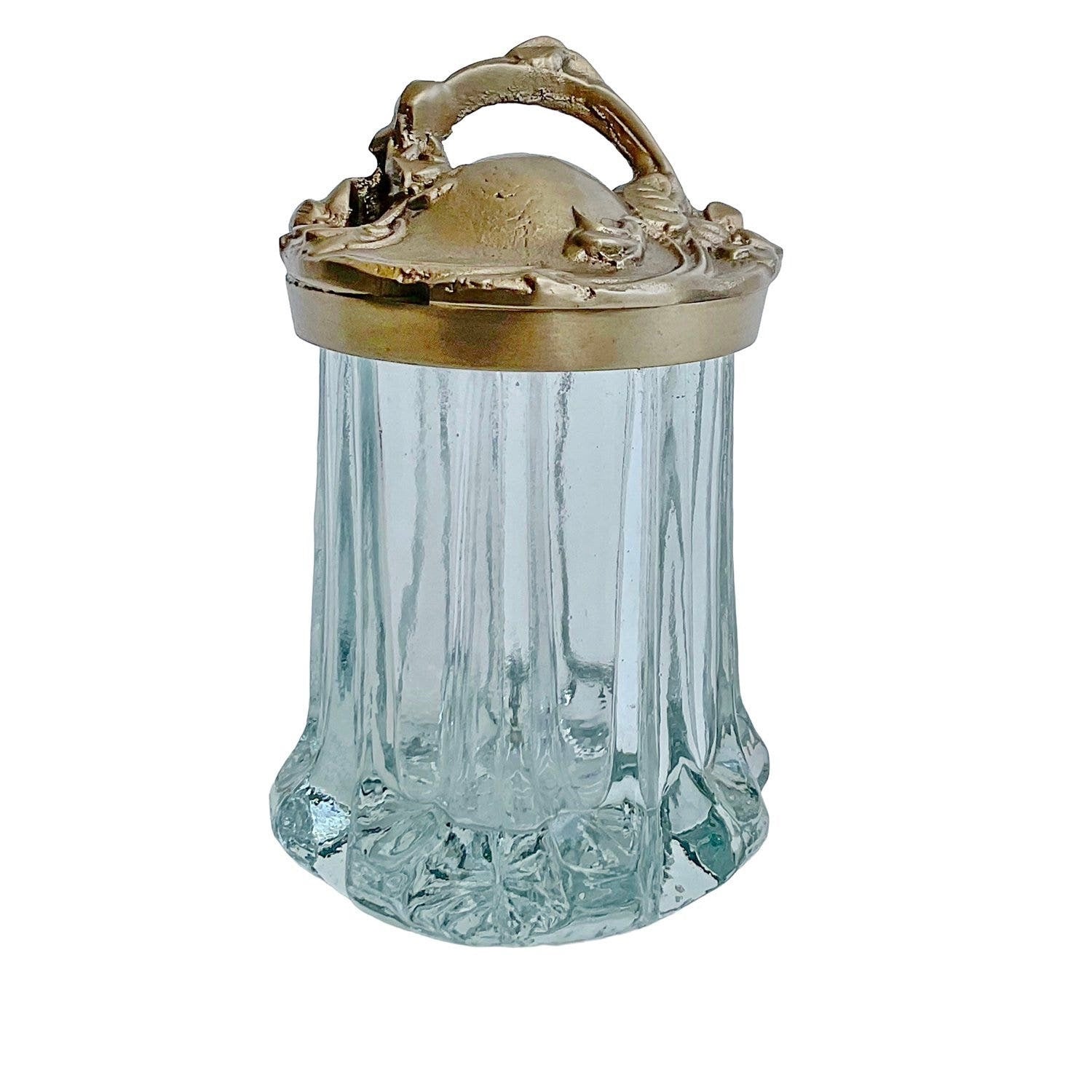 Decorative glass jar with a brass lid on a white background