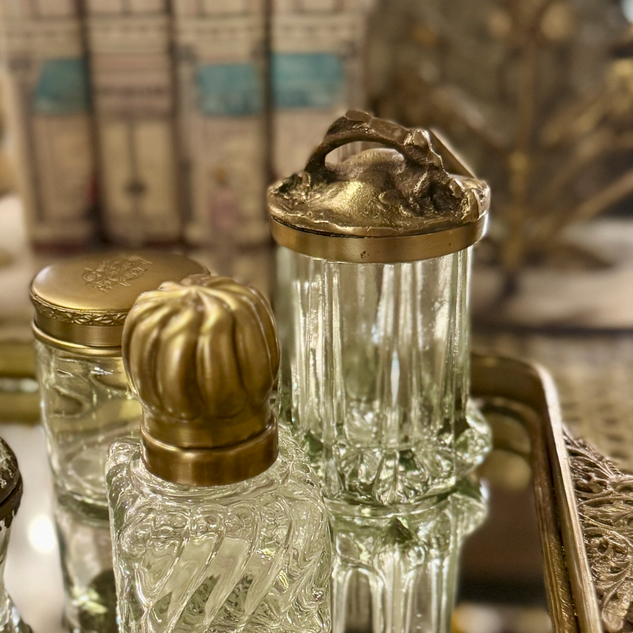 Clear glass bottles with gold lids on a reflective surface