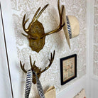Decorative wall hooks with antlers on a patterned wall