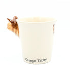 Cat-shaped ceramic mug with 'Orange Tabby' text on a white background