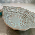 Ceramic dish with wavy edge on a neutral background