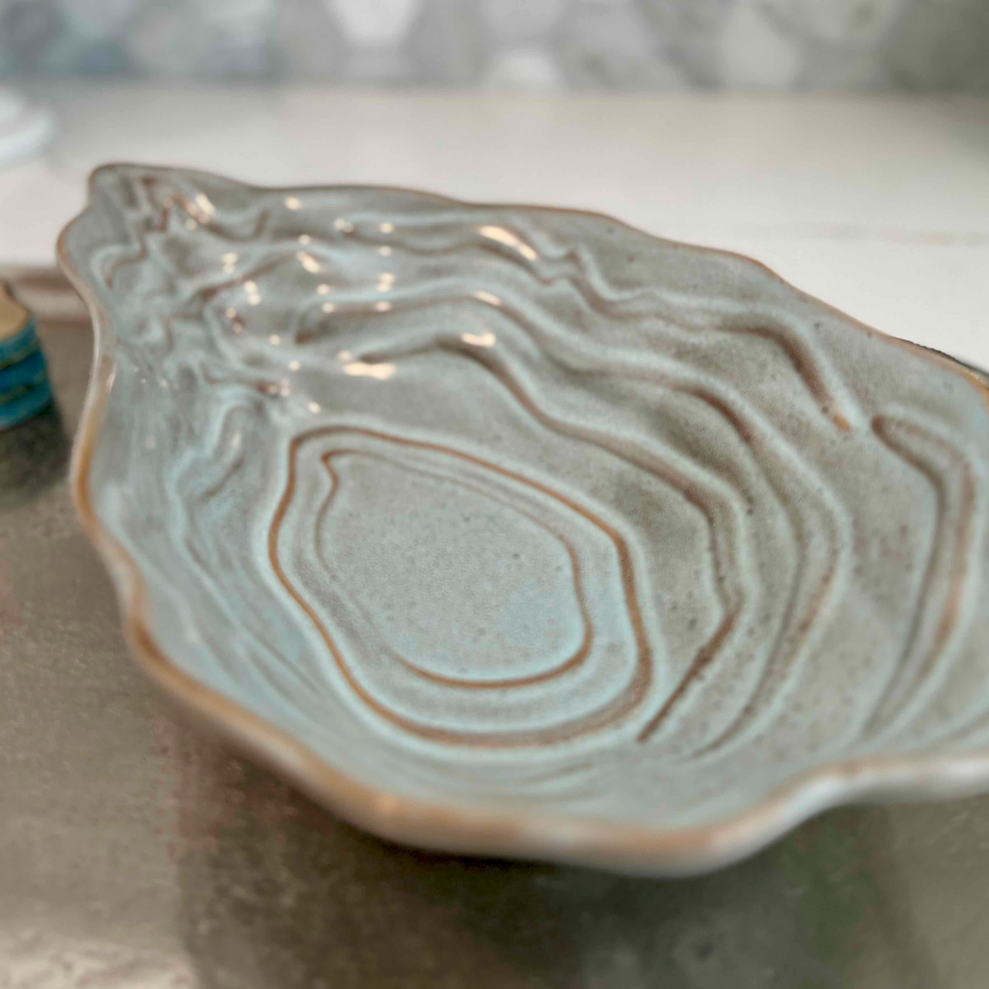 Ceramic dish with wavy edge on a neutral background