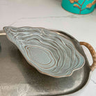 Ceramic leaf-shaped dish on a metal tray with a marble background